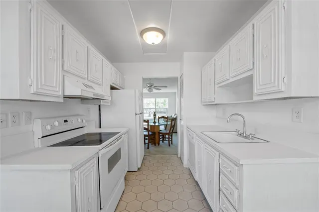 a kitchen with white cabinets and white appliances