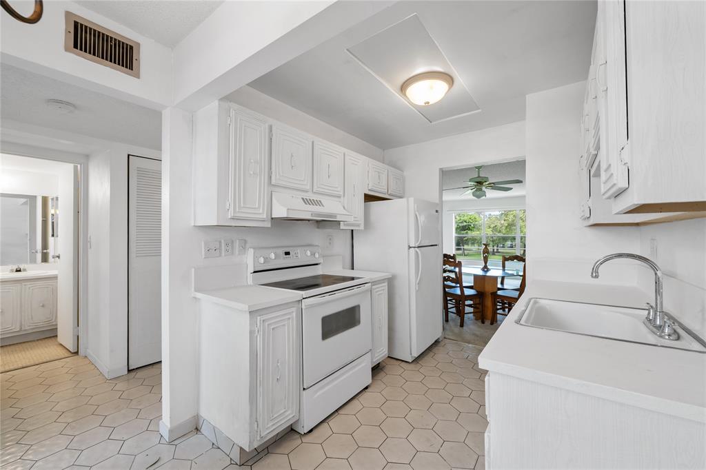 8105 Northwest 61st Street, Unit A206 Tamarac, FL 33321 - Photo 30 of 44 a kitchen with a stove sink and cabinets