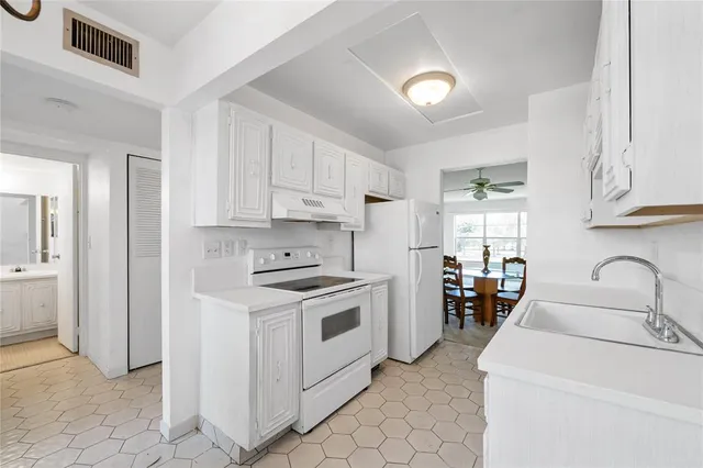 a kitchen with granite countertop a sink stainless steel appliances and cabinets