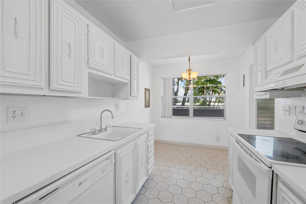 8105 Northwest 61st Street, Unit A206 Tamarac, FL 33321 - Photo 33 of 44 a kitchen with granite countertop a sink stainless steel appliances and cabinets
