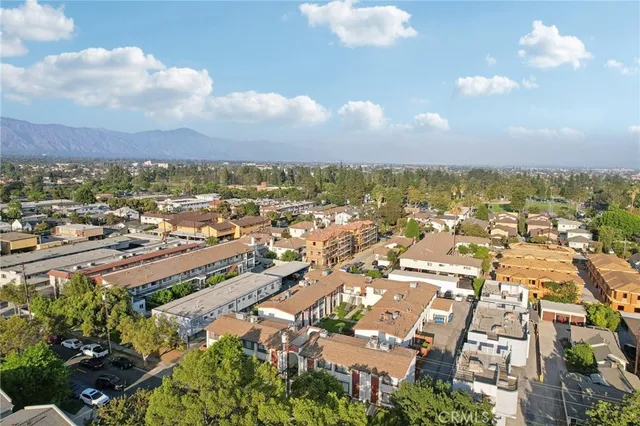 an aerial view of residential houses with outdoor space and trees