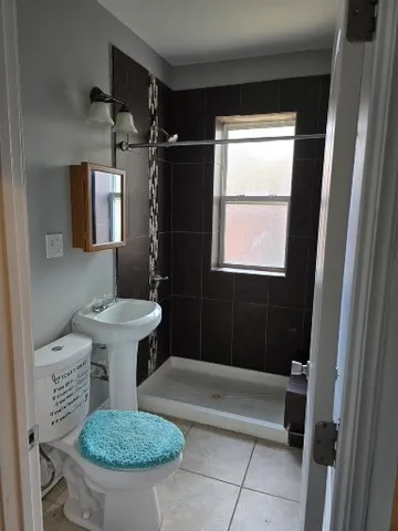 a bathroom with a sink a toilet a mirror and shower