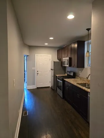 a kitchen with granite countertop stainless steel appliances and wooden cabinets