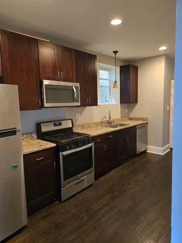 a kitchen with stainless steel appliances granite countertop a stove a microwave and a refrigerator