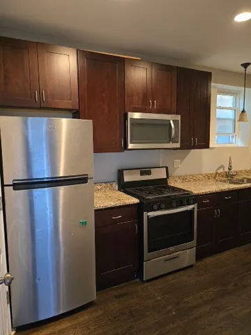 a kitchen with granite countertop wooden cabinets and stainless steel appliances