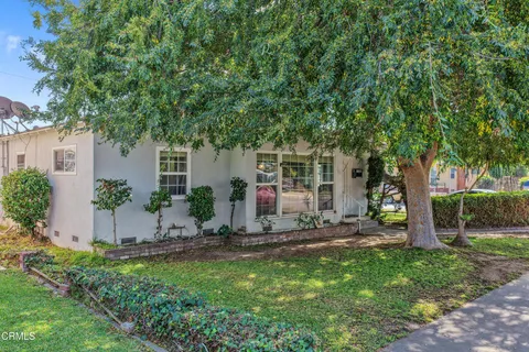 front view of a house with a tree and table