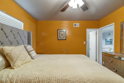 a bedroom with a large bed and a chandelier