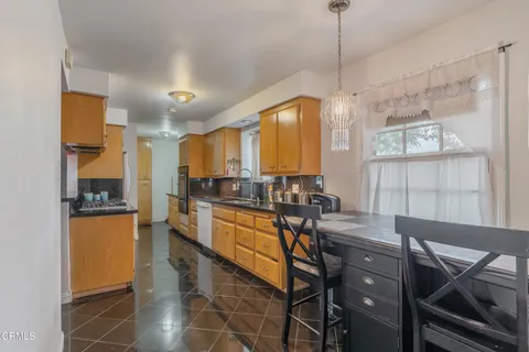 a kitchen with stainless steel appliances kitchen island granite countertop a stove a sink and a refrigerator