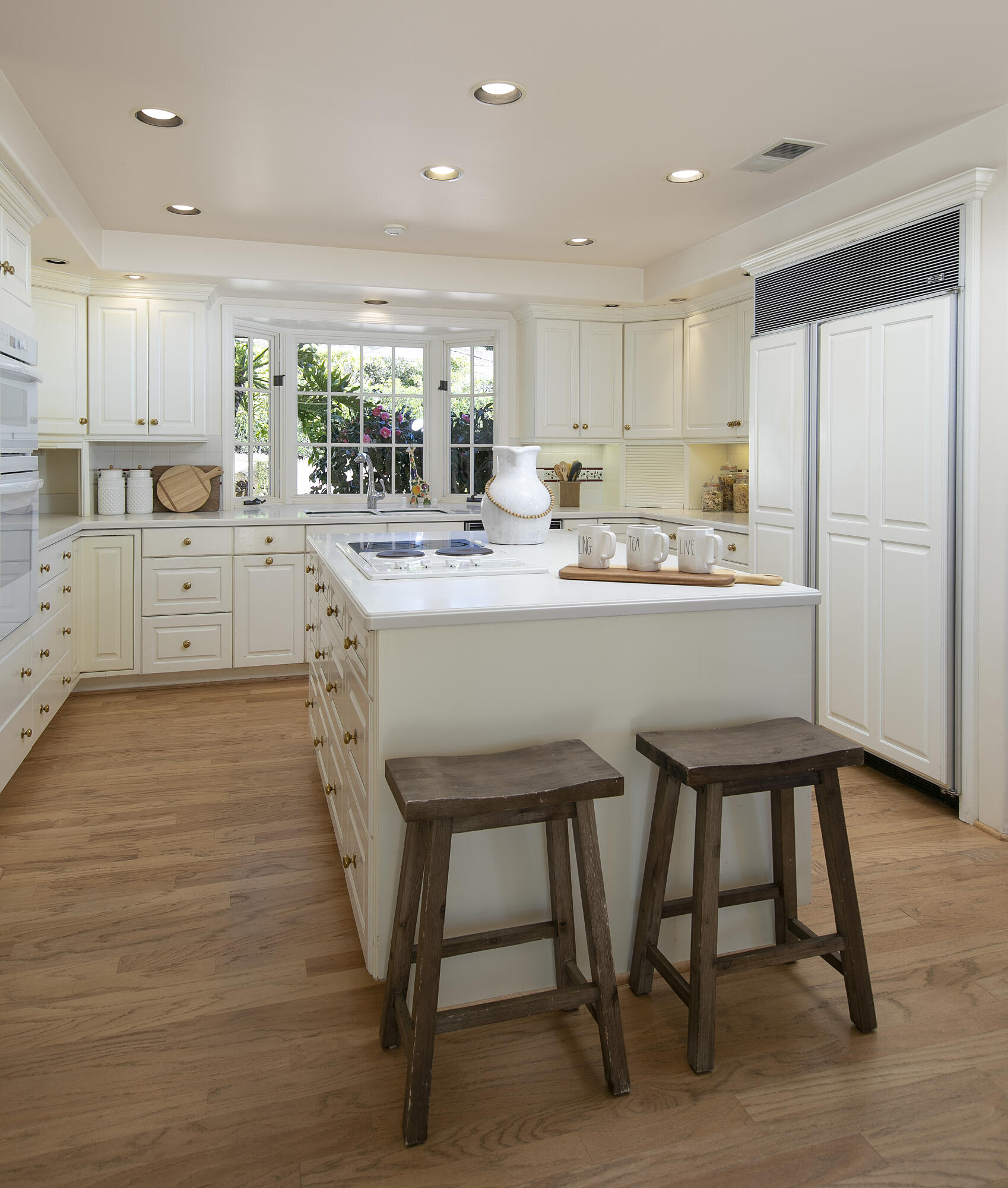 1320 Mission Ridge Road Santa Barbara, CA 93103 - Photo 10 of 27 a kitchen with kitchen island a stove a table and chair with wooden floor