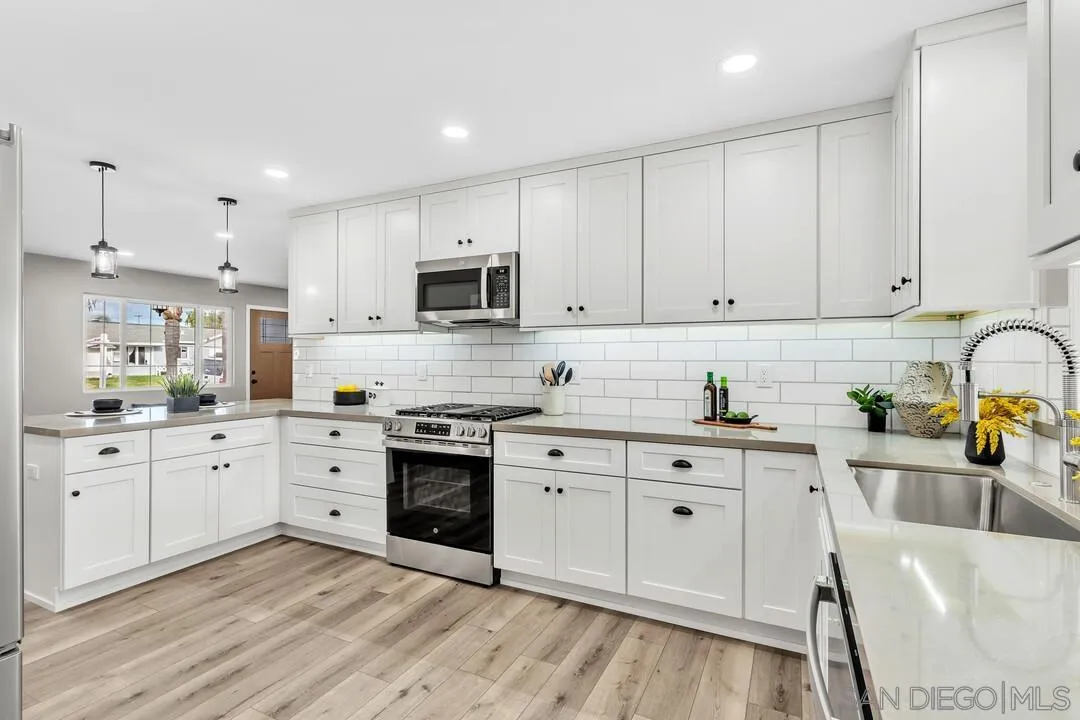 9209 Arnaz Way Santee, CA 92071 - Photo 12 of 39 a kitchen with white cabinets sink and stainless steel appliances