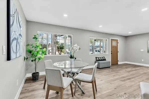 a dining room with furniture and potted plants