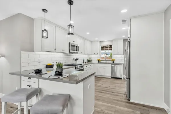 a kitchen with a sink white cabinets and white appliances