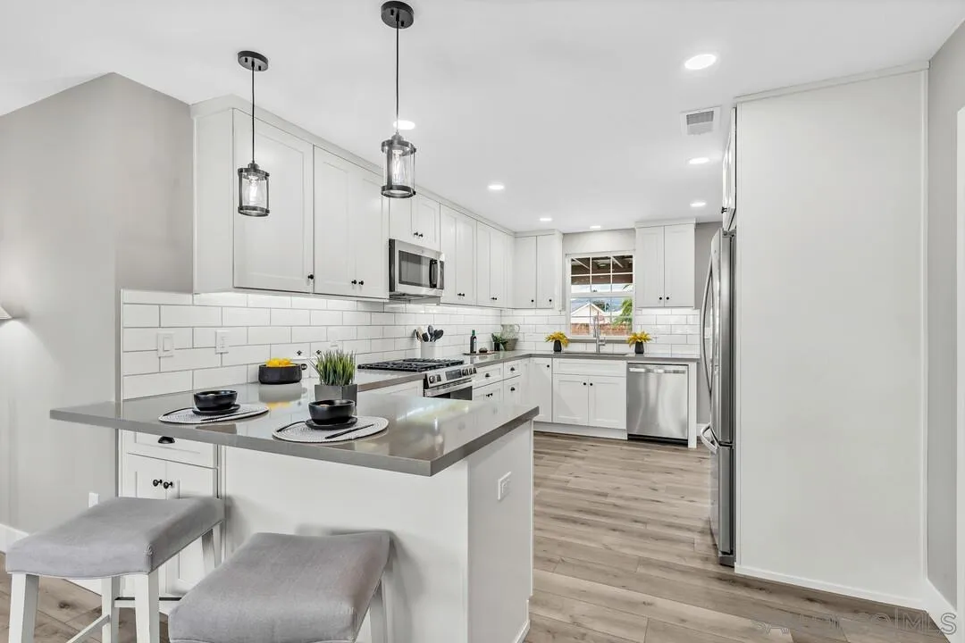 9209 Arnaz Way Santee, CA 92071 - Photo 10 of 39 a kitchen with stainless steel appliances granite countertop a sink a stove a refrigerator and island with wooden floor