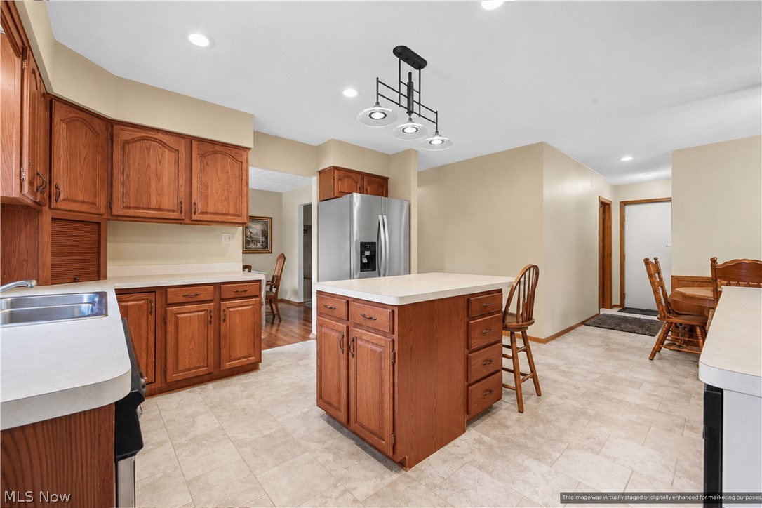 1835 Lynn Road Kent, OH 44240 - Photo 11 of 48 Kitchen featuring wood cabinetry, light-toned countertops, a central island, and stainless steel appliances