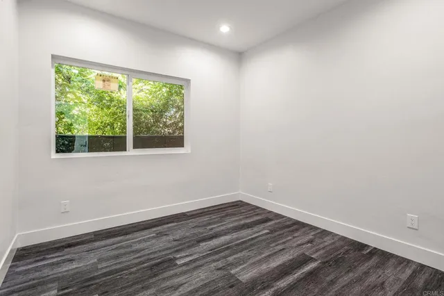 a view of a room with wooden floor and window