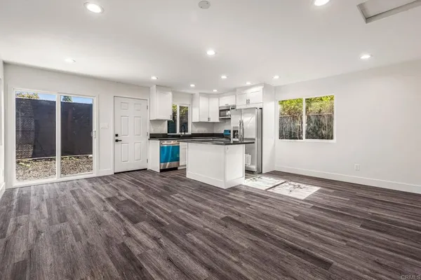 a kitchen with stainless steel appliances granite countertop a refrigerator a stove top oven a sink and dishwasher