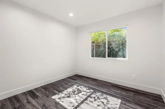 an empty room with wooden floor and a window