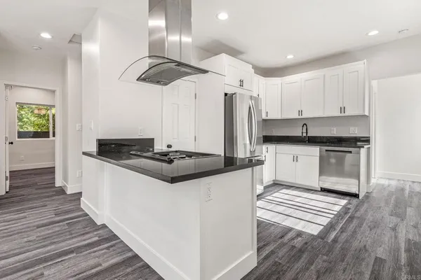 a kitchen with stainless steel appliances granite countertop a stove a sink and a refrigerator