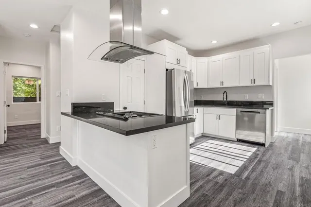 a kitchen with stainless steel appliances granite countertop a stove a sink and a refrigerator