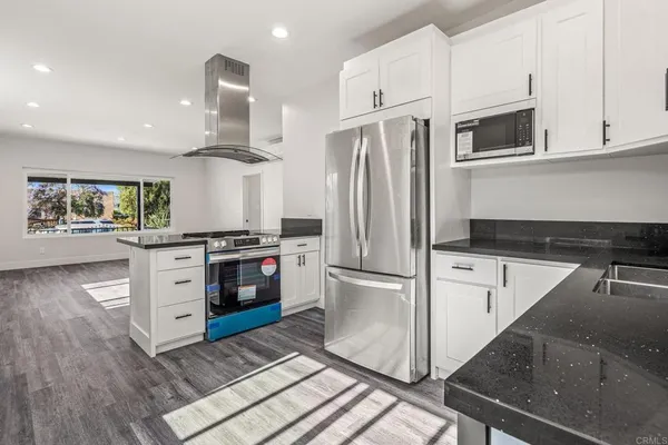 a kitchen with white cabinets and stainless steel appliances