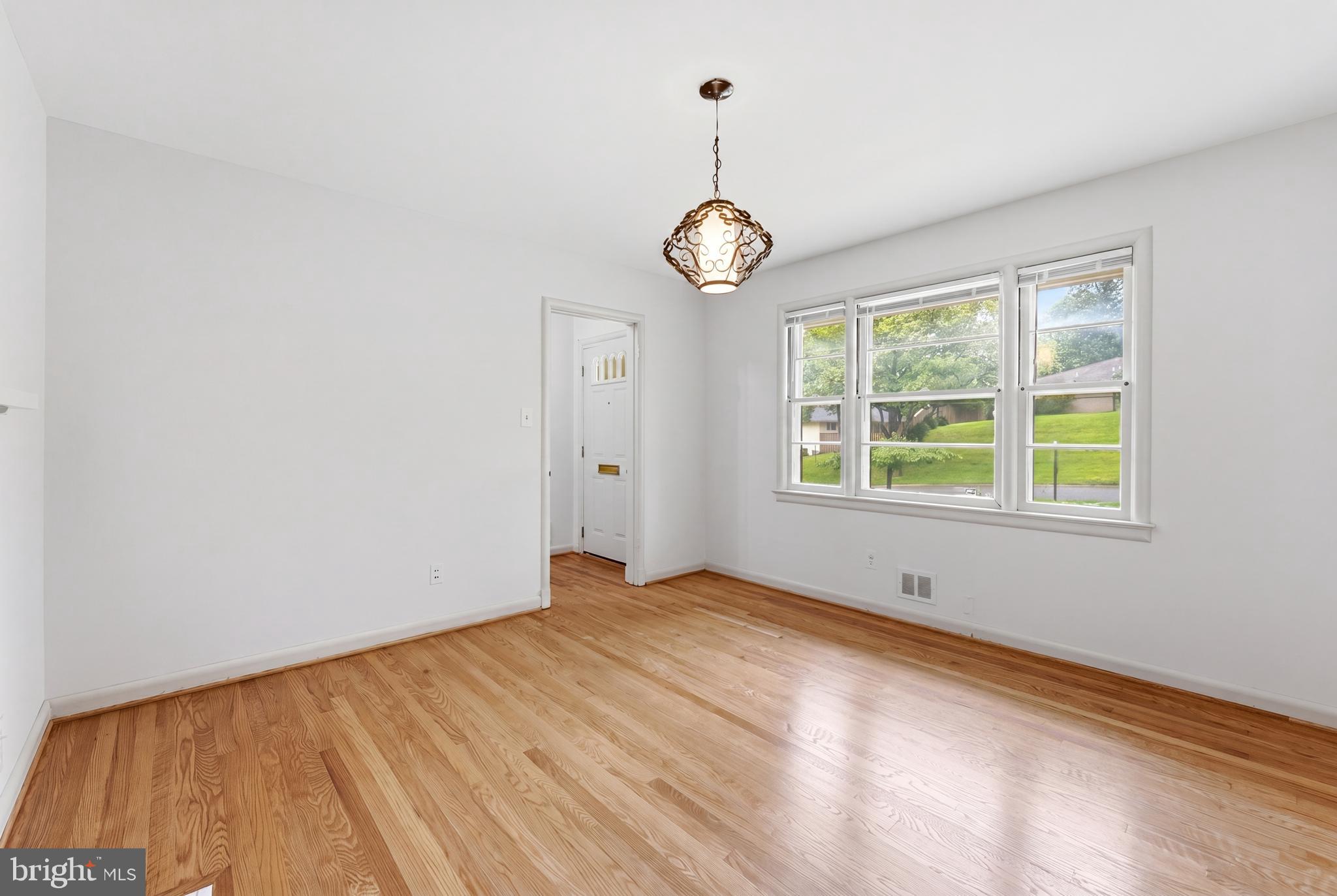 228 Northwest Terrace Silver Spring, MD 20901 - Photo 6 of 70 a view of an empty room with wooden floor and windows