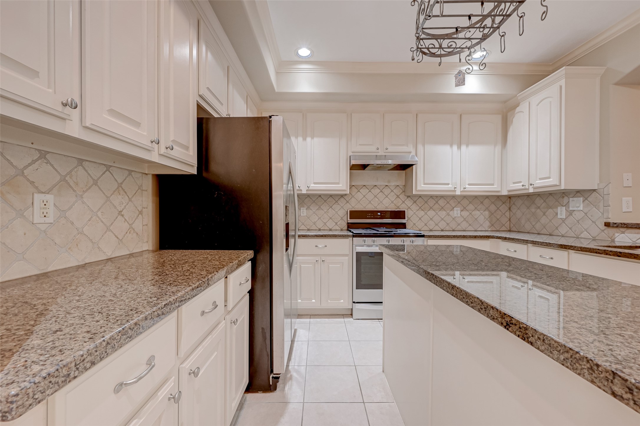 13607 Brookbluff Lane Houston, TX 77077 - Photo 28 of 50 a kitchen with granite countertop white cabinets and stainless steel appliances