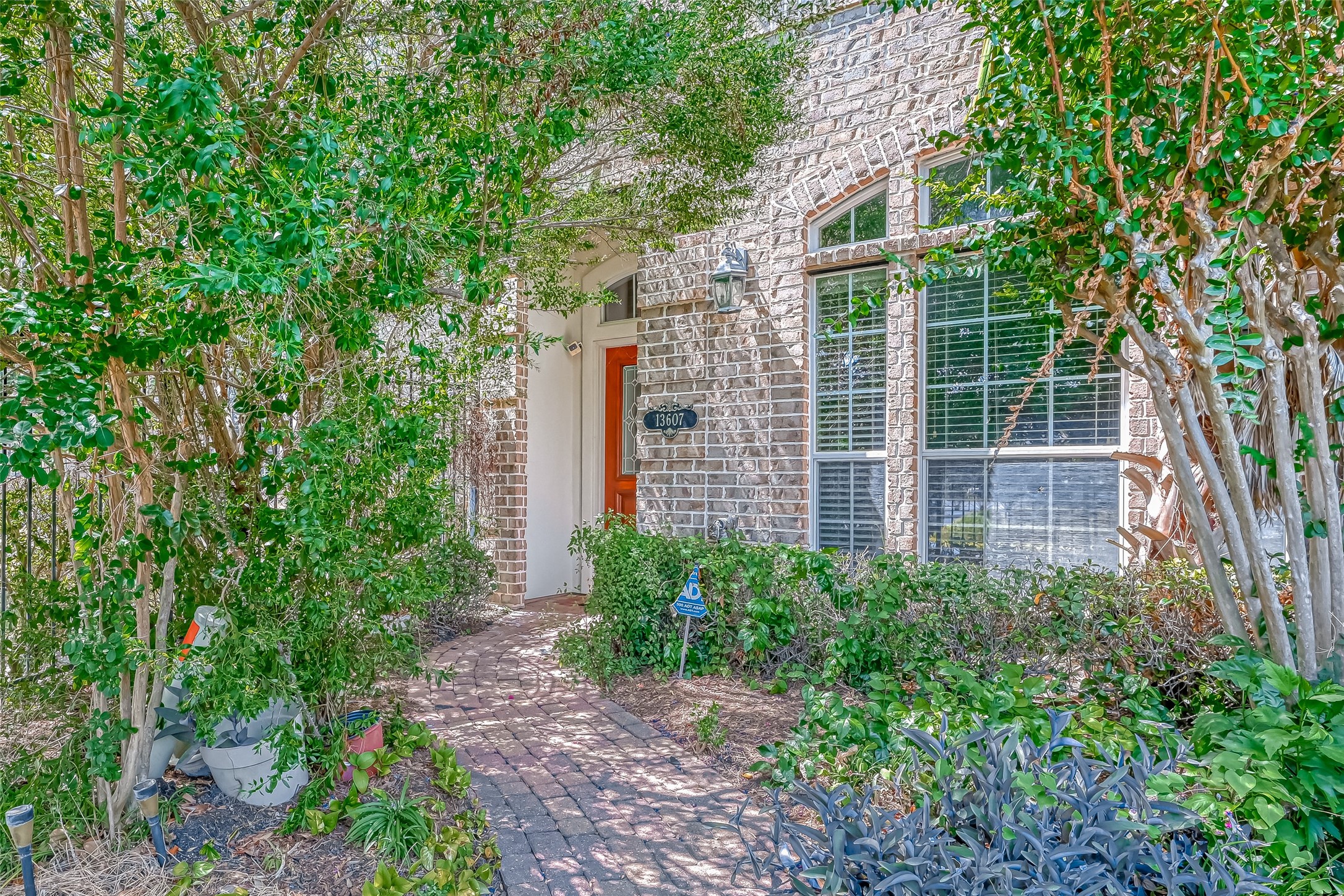 13607 Brookbluff Lane Houston, TX 77077 - Photo 3 of 50 a view of a pathway of a house with plants and large trees