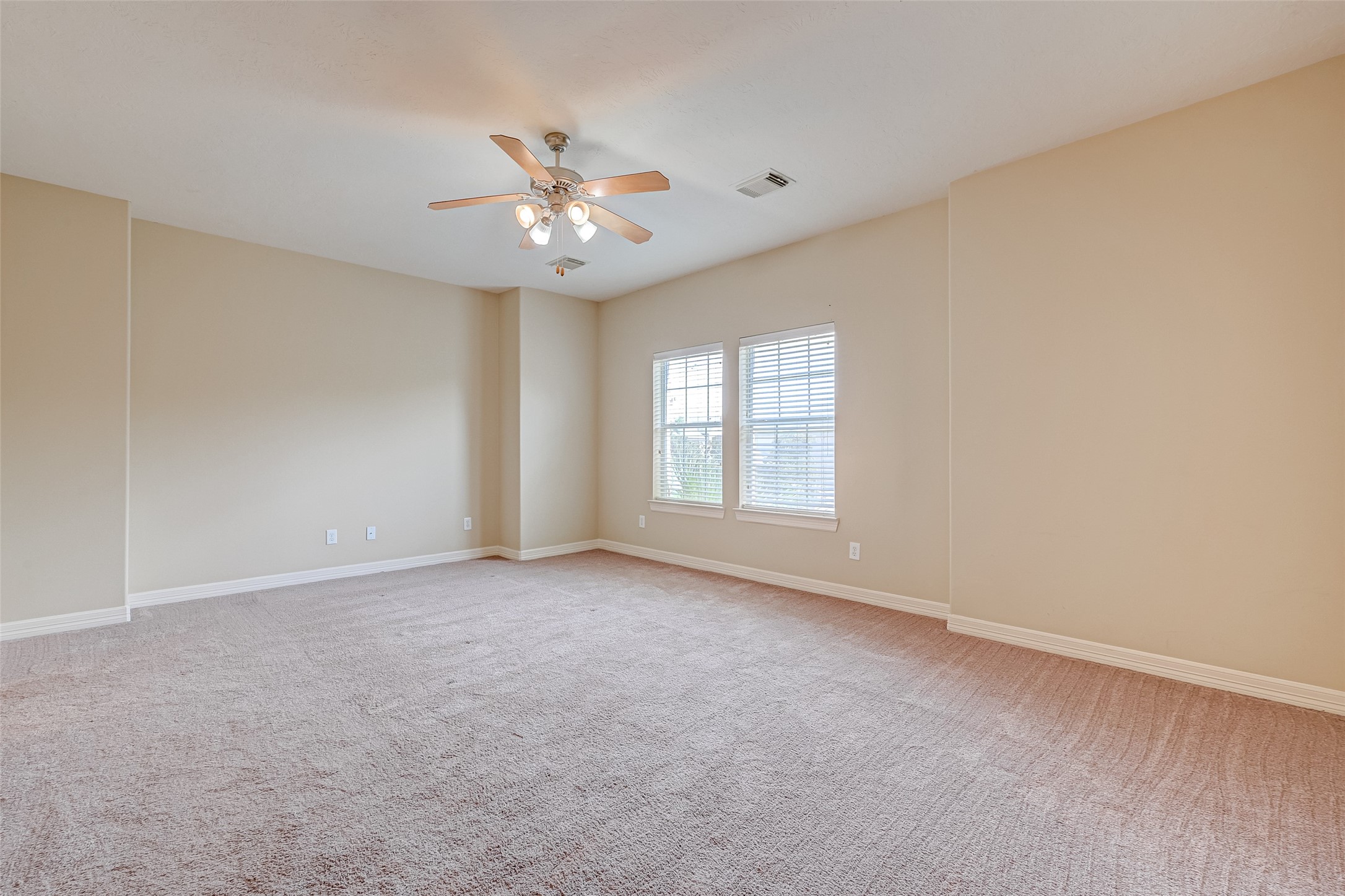 13607 Brookbluff Lane Houston, TX 77077 - Photo 36 of 50 an empty room with chandelier fan and windows