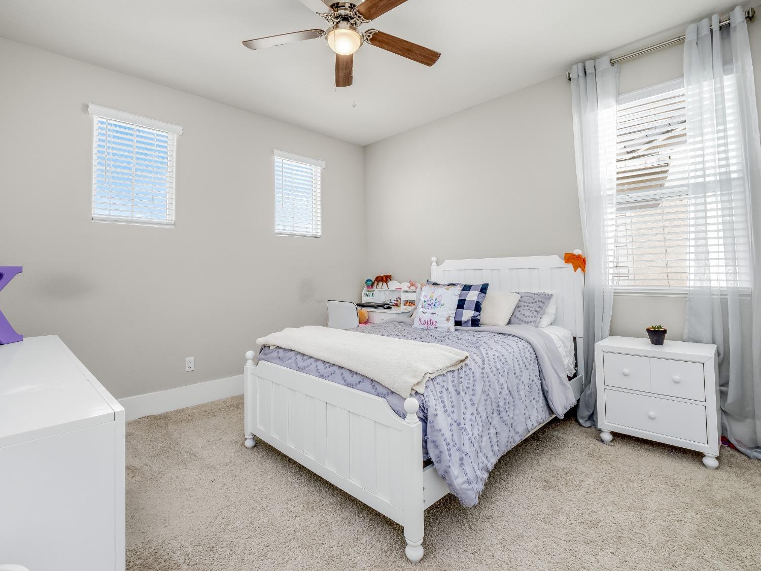 4289 Vineyard Drive Madera, CA 93636 - Photo 20 of 37 a bedroom with a bed and a chandelier