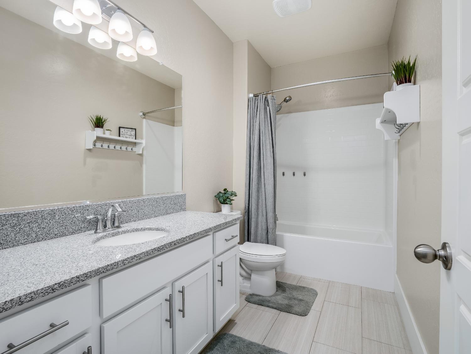 4289 Vineyard Drive Madera, CA 93636 - Photo 21 of 37 a bathroom with a sink a toilet a mirror and shower