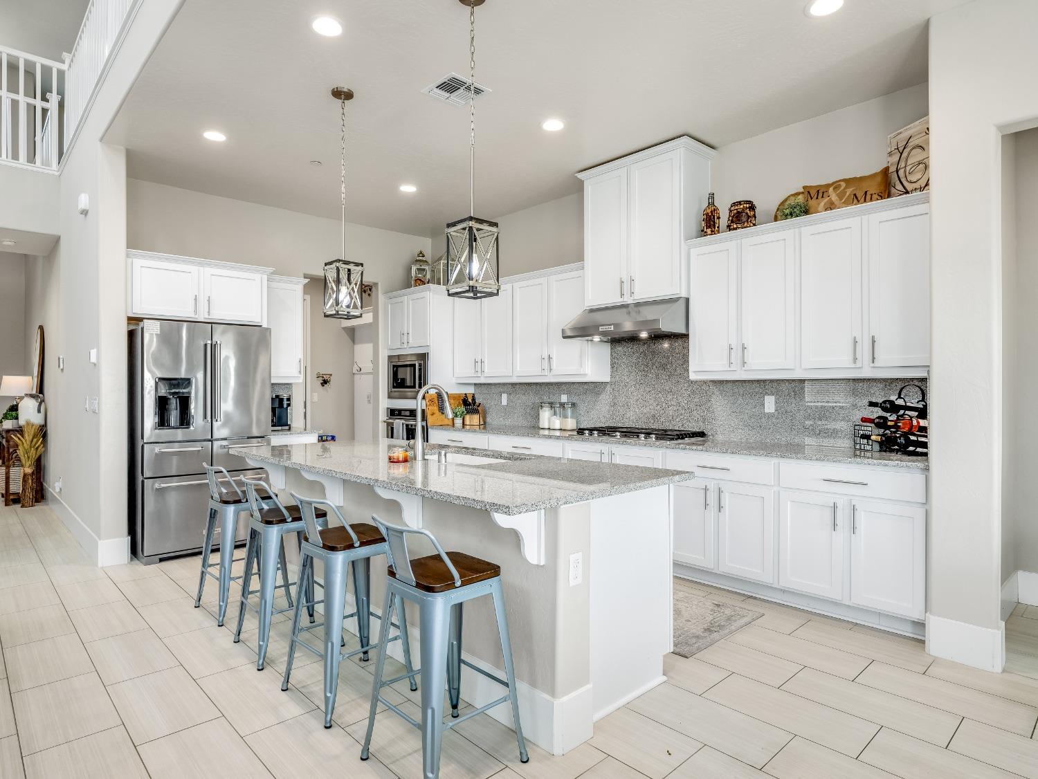 4289 Vineyard Drive Madera, CA 93636 - Photo 5 of 37 a kitchen with cabinets and chairs