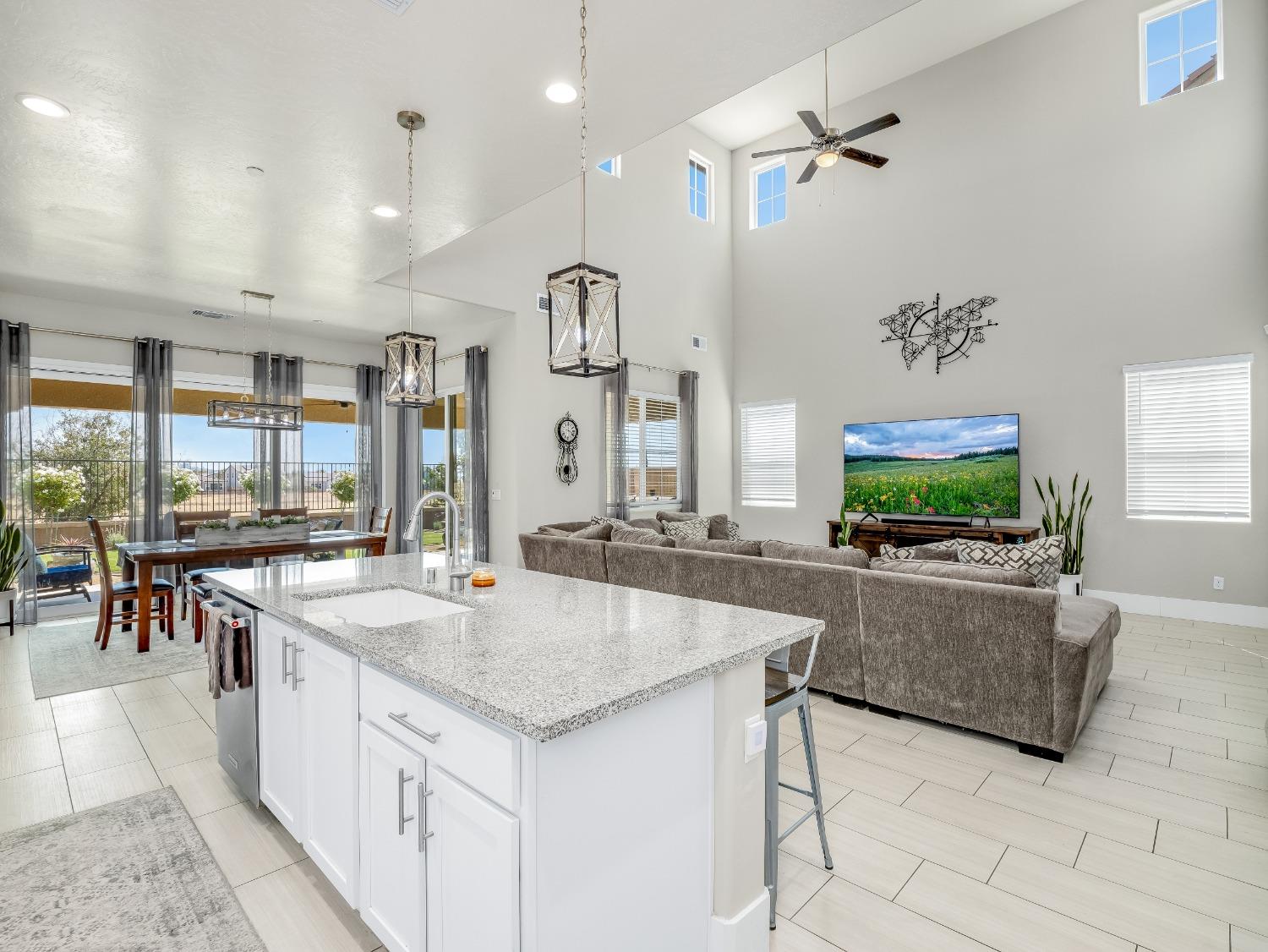 4289 Vineyard Drive Madera, CA 93636 - Photo 9 of 37 a living room with stainless steel appliances kitchen island granite countertop a table chairs and a refrigerator