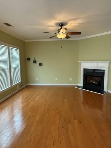 an empty room with a fireplace and wooden floor