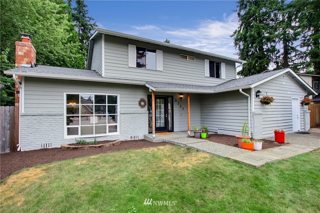 2327 168th Street Southeast Bothell, WA 98012 - Photo 1 of 25 a backyard of a house with potted plants and a large tree