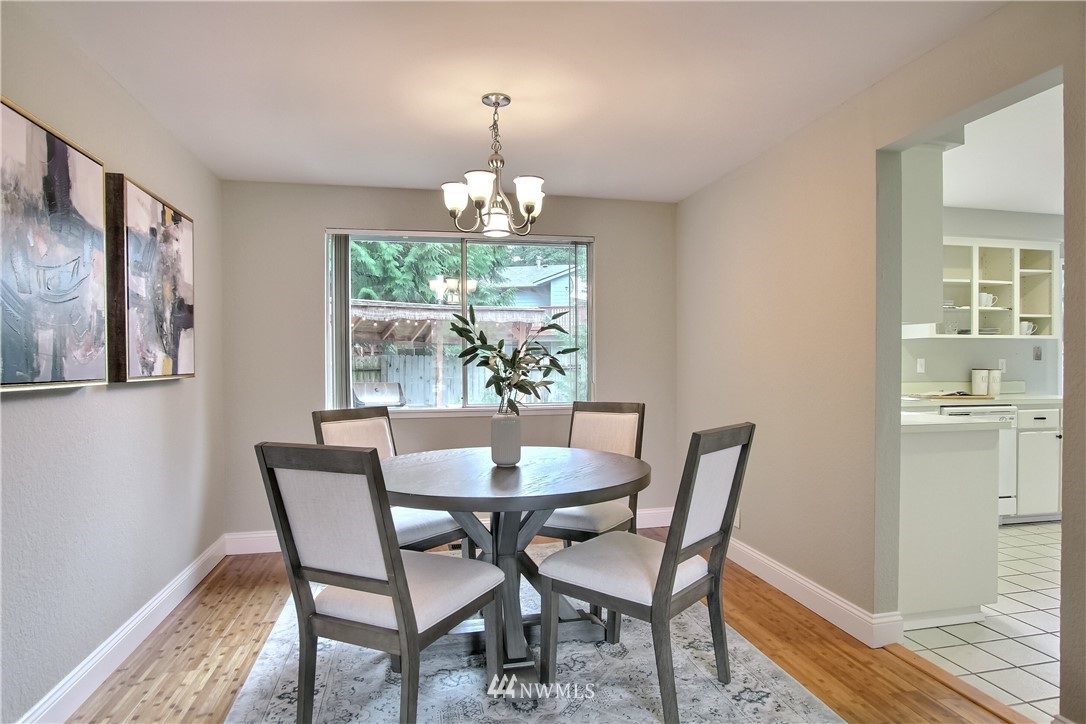 2327 168th Street Southeast Bothell, WA 98012 - Photo 8 of 25 a view of a dining room with furniture a chandelier and wooden floor