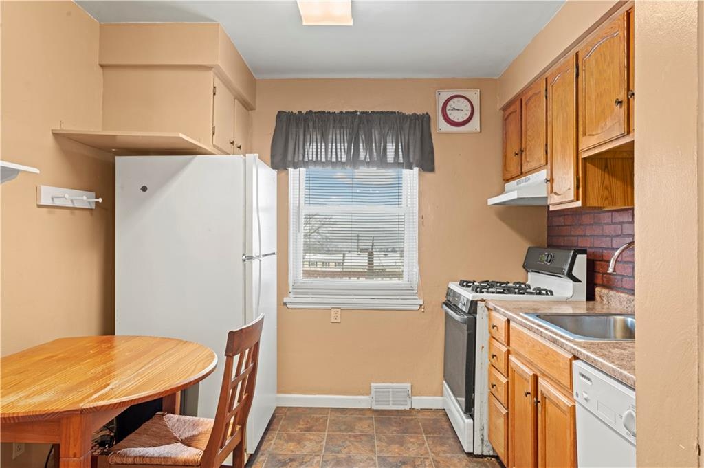 720 6th Street Verona, PA 15147 - Photo 18 of 28 a kitchen that has a stove and a table in it