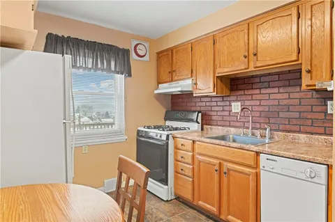 a kitchen with stainless steel appliances granite countertop a sink stove and cabinets