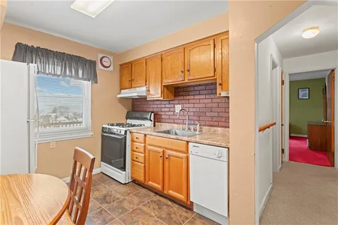 a kitchen with stainless steel appliances granite countertop a stove a refrigerator a sink dishwasher with a dining table and chair