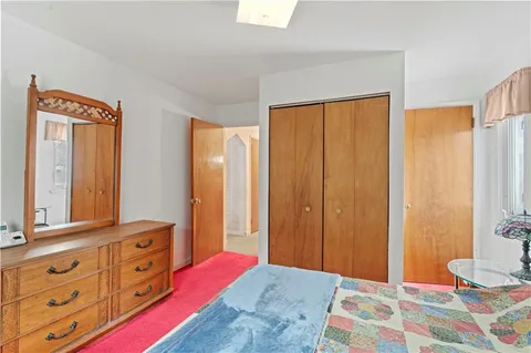 a bedroom with a bed and a dresser in it