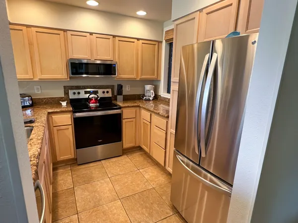 a kitchen with stainless steel appliances granite countertop a refrigerator stove and microwave