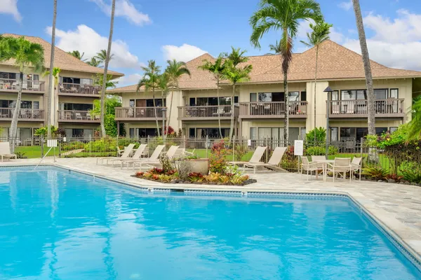 a view of a swimming pool with a lawn chairs under an umbrella