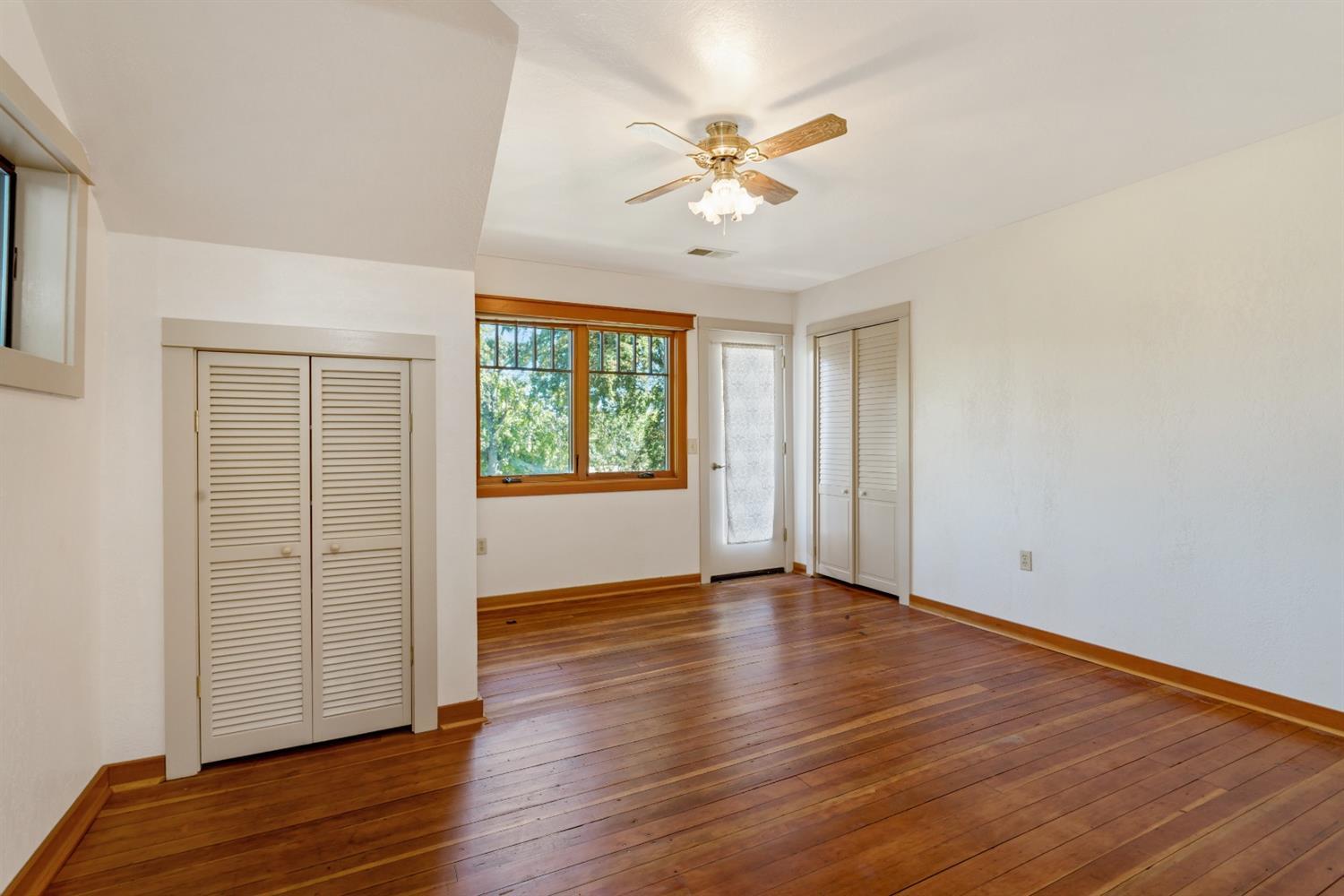 4410 Colver Road Phoenix, OR 97535 - Photo 23 of 35 an empty room with wooden floor chandelier fan and windows