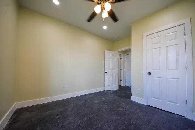an empty room with a ceiling fan and a window