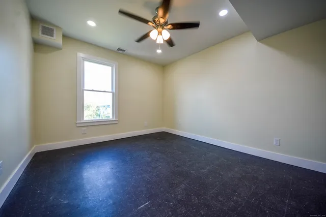 an empty room with a window and a fan