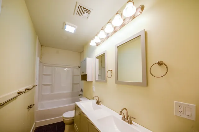 a bathroom with a sink a toilet and shower