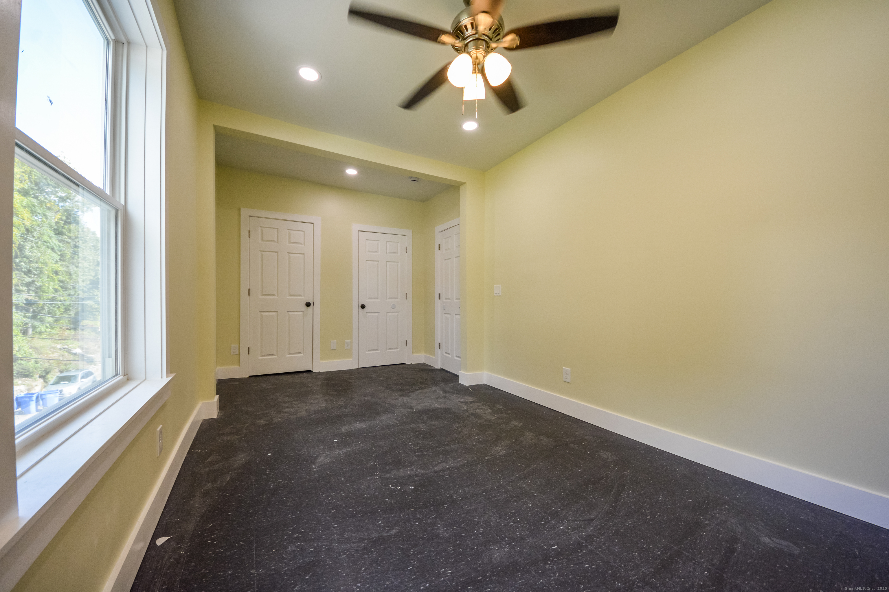 92 High Street, Unit 4W Waterbury, CT 06704 - Photo 6 of 22 an empty room with a chandelier fan and windows