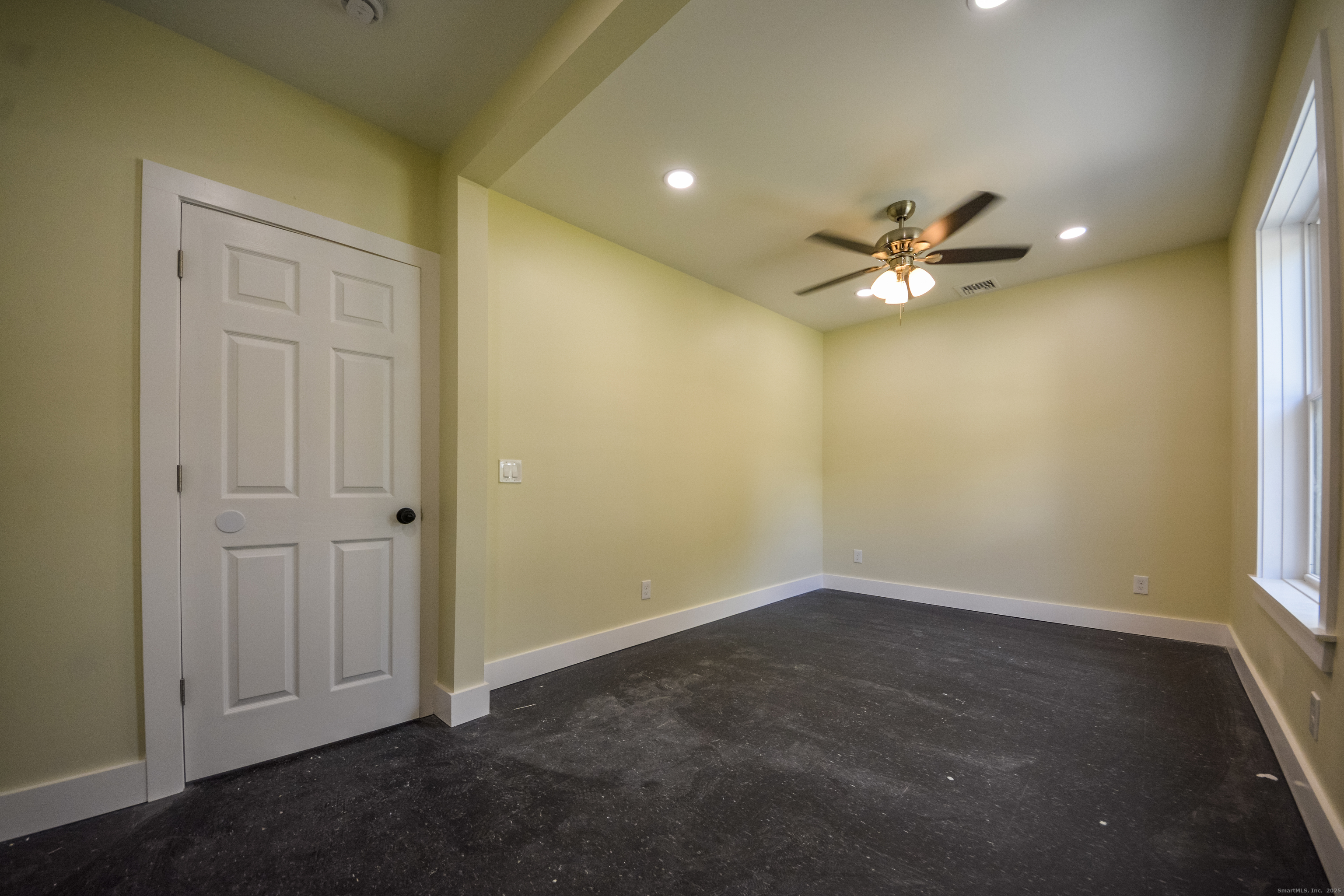 92 High Street, Unit 4W Waterbury, CT 06704 - Photo 8 of 22 an empty room with a chandelier fan and windows