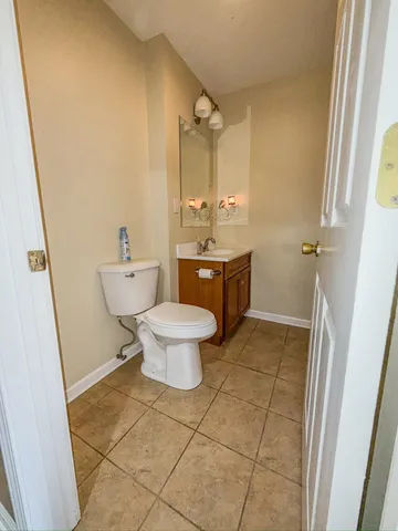 an empty room with wooden floor chandelier and windows