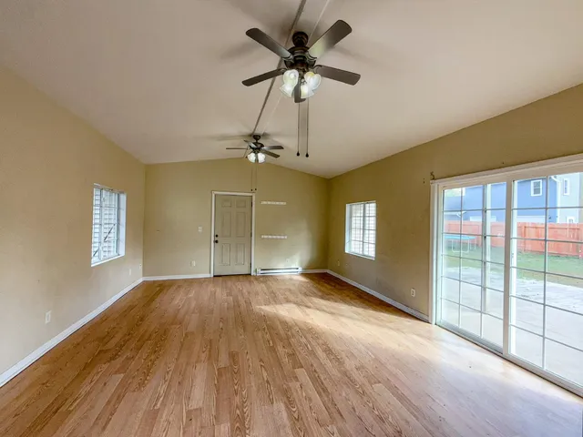 an empty room with windows and fan