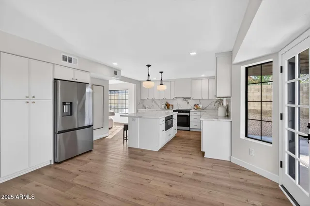 a kitchen with stainless steel appliances granite countertop a refrigerator and a stove top oven